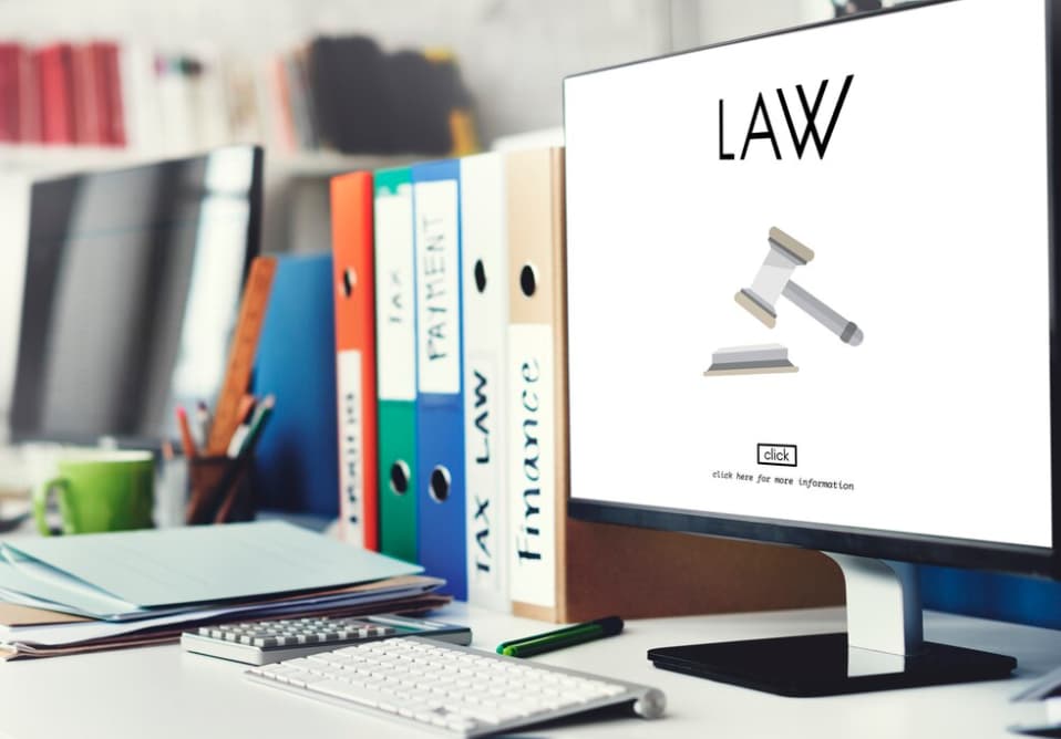 A desktop screen displaying "LAW" with legal books and binders on a desk