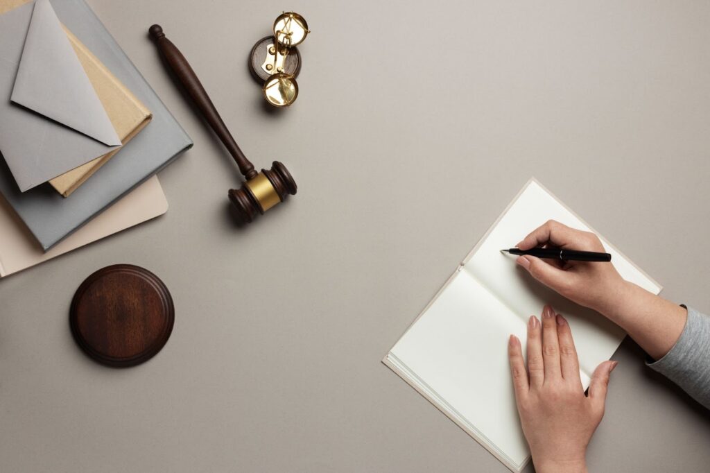 Top view of woman writing in notebook near items for judges